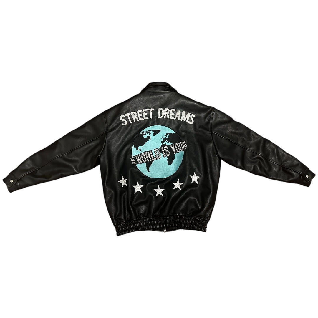 Back view of black faux leather jacket with a globe design, 'Street Dreams' text, 'The World is Yours' slogan, and star accents, perfect for urban streetwear style.